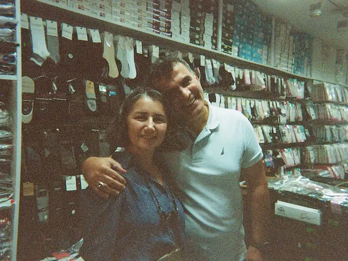 Murat and Jale, owners of Goren Socks, in the family shop surrounded by shelves of socks