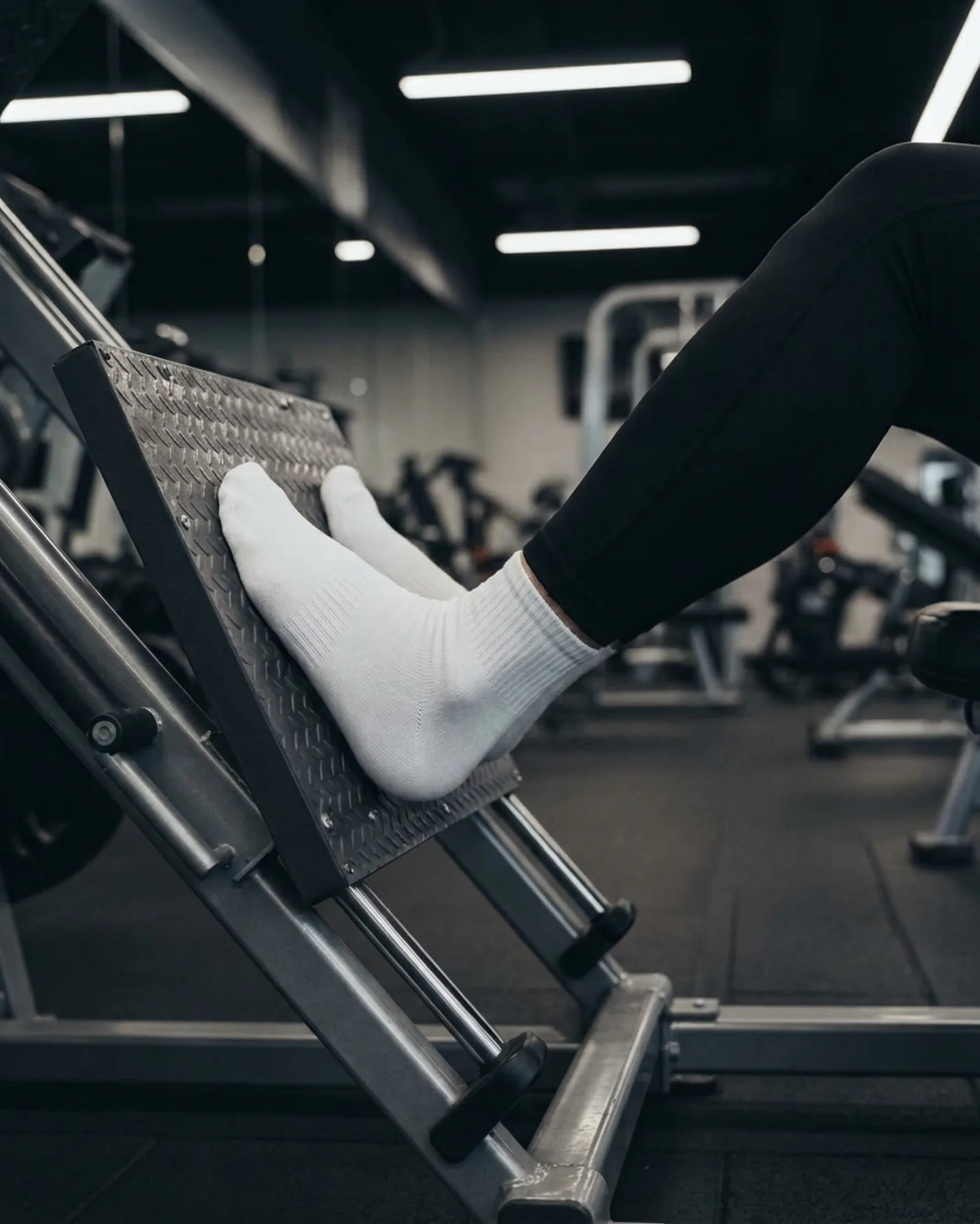 White sports socks worn during a leg press workout