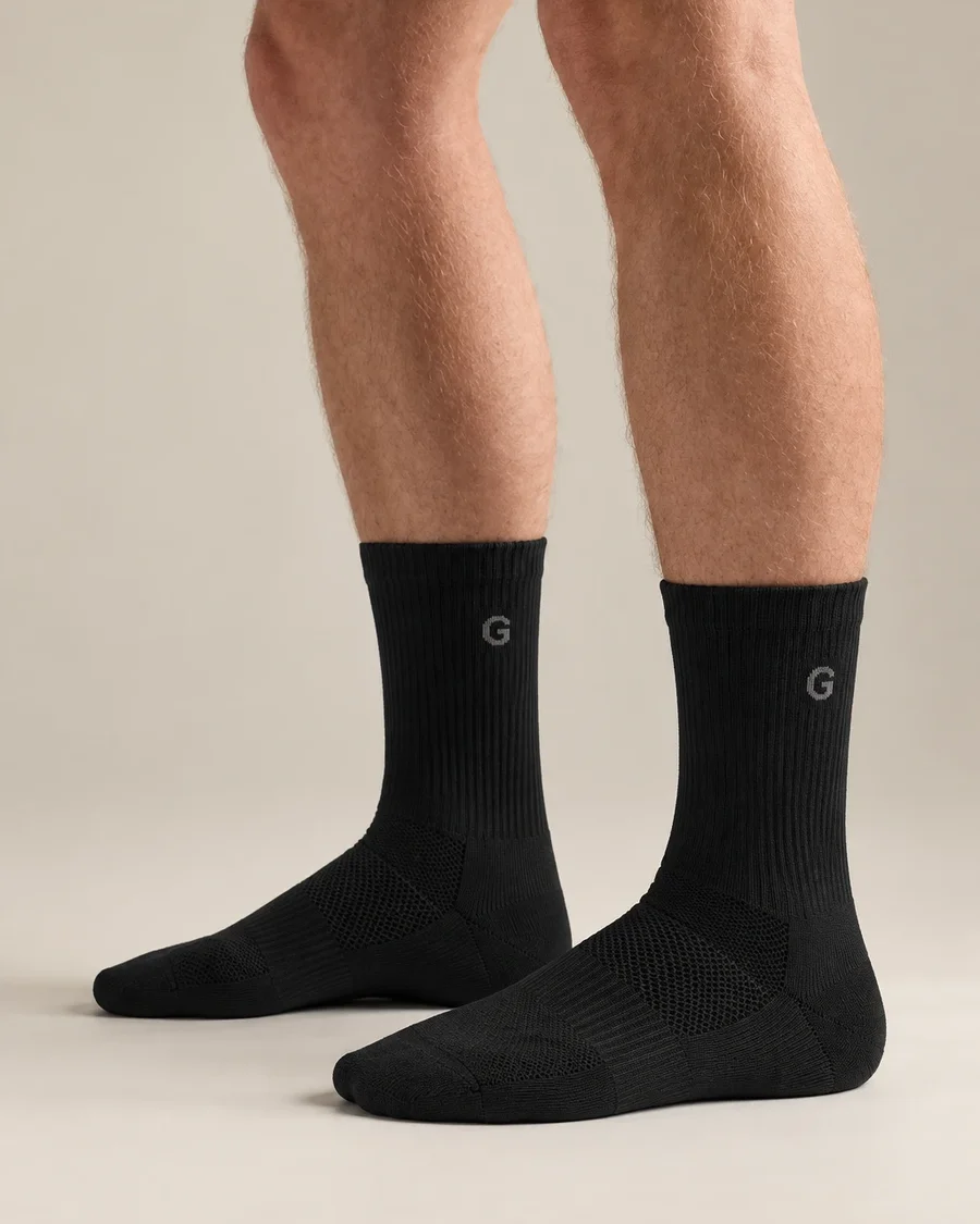 Black running socks with a knitted logo on the shaft